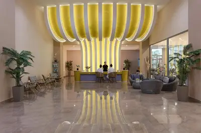 a lobby with a large yellow and yellow chandelier at Atrium Platinum Resort & Spa in Ixia