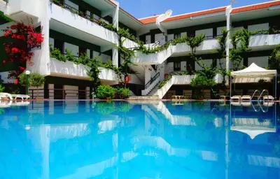 a swimming pool in front of a building at Terinikos Sunny Garden Hotel & Junior Suites in Ialyssos