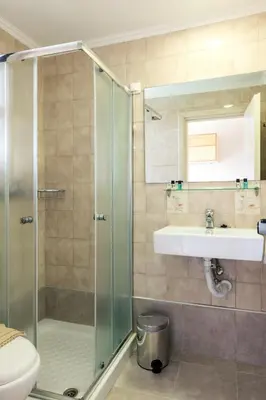 a bathroom with a shower and a sink at Terinikos Sunny Garden Hotel & Junior Suites in Ialyssos