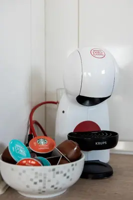 a coffee maker sitting next to a bowl of chocolates at Terinikos Sunny Garden Hotel & Junior Suites in Ialyssos