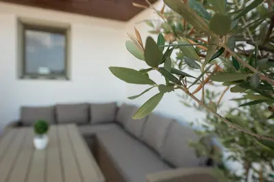 a living room with a couch and a table at Terinikos Sunny Garden Hotel & Junior Suites in Ialyssos