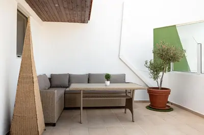 a patio with a couch and a table at Terinikos Sunny Garden Hotel & Junior Suites in Ialyssos