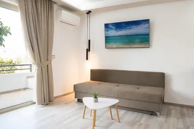 a living room with a couch and a table at Terinikos Sunny Garden Hotel & Junior Suites in Ialyssos