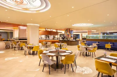 a restaurant with tables and chairs and a cafeteria at Doreta Beach in Theologos