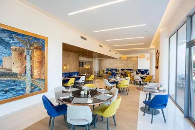 a restaurant with tables and chairs and a painting on the wall at Doreta Beach in Theologos