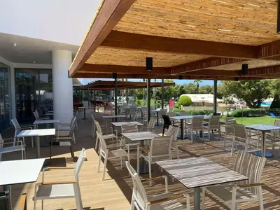 an outdoor patio with tables and chairs and tables and tablesearcher at Doreta Beach in Theologos