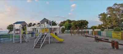 a playground with a yellow slide at Doreta Beach in Theologos
