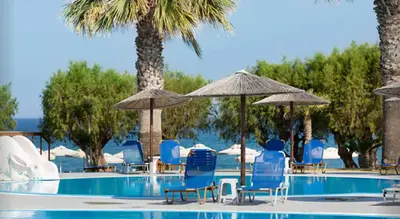 a swimming pool with chairs and umbrellas at Doreta Beach in Theologos