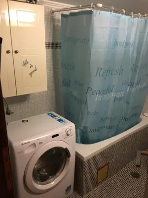 a washing machine in a bathroom with a shower curtain at Matrel Home in Rhodes Town