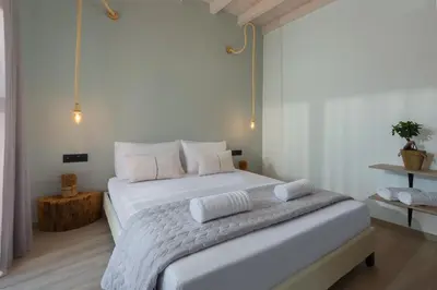 a bedroom with a white bed with white sheets and pillows at Southrock Villas in Lachania