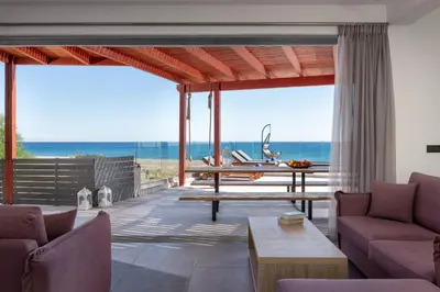 a living room with a table and a view of the ocean at Southrock Villas in Lachania
