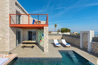 a villa with a swimming pool and a deck at Southrock Villas in Lachania