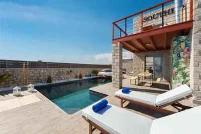 a villa with a swimming pool and a patio at Southrock Villas in Lachania