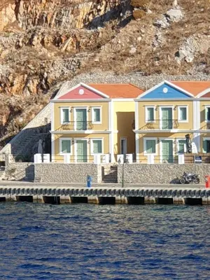 a row of houses on a dock in the water at Sea Stars ,Villas Danezis in Symi