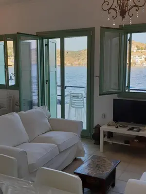 a living room with a couch and a view of the water at Sea Stars ,Villas Danezis in Symi
