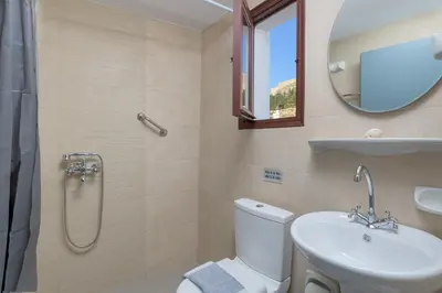 a bathroom with a toilet and a sink and a mirror at Erato Apartments in Líndos
