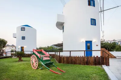 a green wagon in front of a lighthouse at Christina Dream Village in Pastida