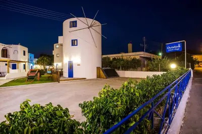 a white building with a windmill at night at Christina Dream Village in Pastida