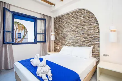 a bedroom with a bed and a brick wall at Christina Dream Village in Pastida