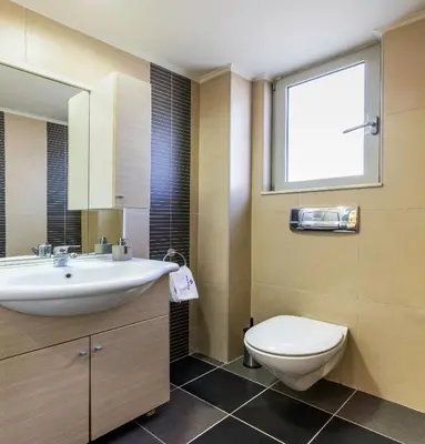 a bathroom with a sink and a toilet and a window at Rhodes Central Suite in Rhodes Town