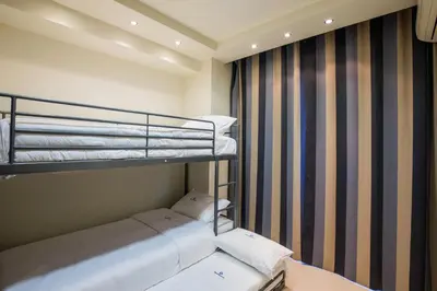 a small room with two bunk beds and a window at Rhodes Central Suite in Rhodes Town