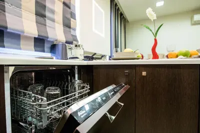 a kitchen with a dishwasher with glasses in it at Rhodes Central Suite in Rhodes Town