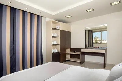a bedroom with a bed and a desk and a sink at Rhodes Central Suite in Rhodes Town