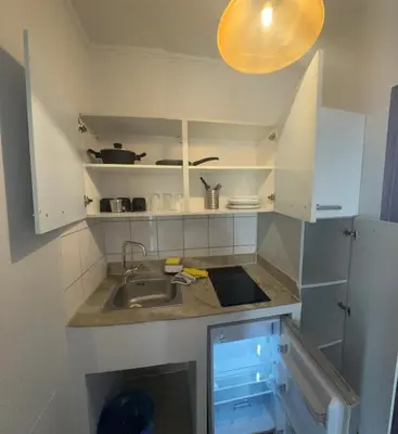 a small kitchen with white cabinets and a sink at Comfort Hotel Apartments in Rhodes Town