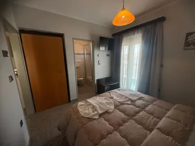 a bedroom with a bed and a large window at Comfort Hotel Apartments in Rhodes Town
