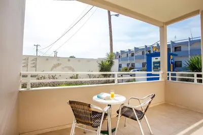 a balcony with a table and chairs and a view of the beach at Saint Amon Hotel in Faliraki