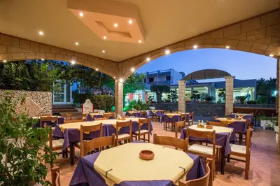 a restaurant with tables and chairs with purple table cloth at Saint Amon Hotel in Faliraki