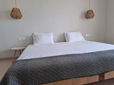a bedroom with a large bed with white sheets and pillows at Hotel Platon in Faliraki
