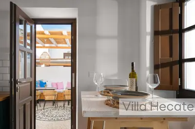 a kitchen with a table with wine glasses on it at Lindos Amphitheater Villas and Apartments in Líndos