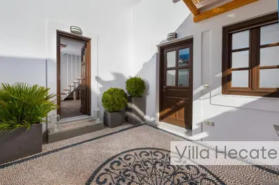 a facade of a house with doors and potted plants at Lindos Amphitheater Villas and Apartments in Líndos