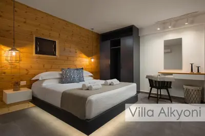 a bedroom with a large bed and a desk at Lindos Amphitheater Villas and Apartments in Líndos