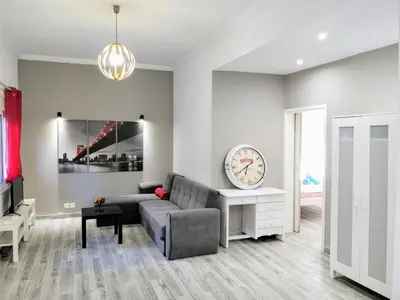 a living room with a couch and a clock at Amazing apartment 100 meters from the Old Town in Rhodes Town