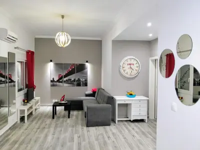 a living room with a couch and a clock on the wall at Amazing apartment 100 meters from the Old Town in Rhodes Town