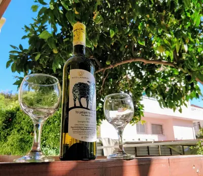 a bottle of wine and two wine glasses on a table at Amazing apartment 100 meters from the Old Town in Rhodes Town