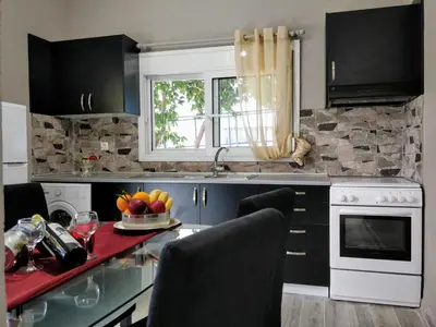a kitchen with black cabinets and a table with fruit on it at Amazing apartment 100 meters from the Old Town in Rhodes Town