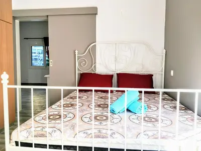 a white bed with two red pillows in a bedroom at Amazing apartment 100 meters from the Old Town in Rhodes Town