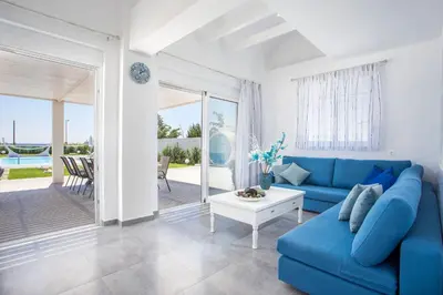 a living room with a blue couch and a table at White Passion in Afantou