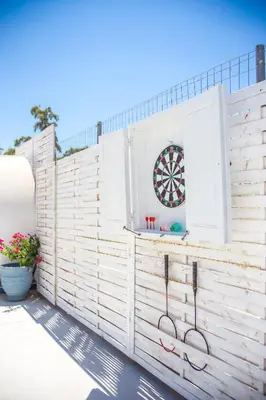 a wooden fence with a dart board in a window at White Passion in Afantou