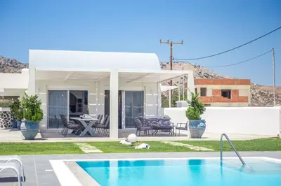 a villa with a swimming pool in front of a house at White Passion in Afantou