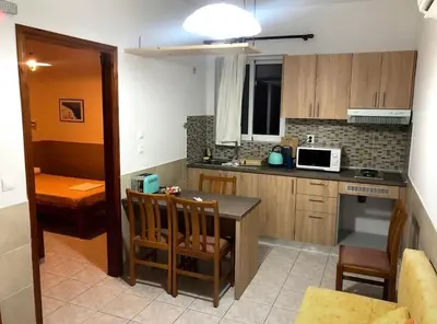 a kitchen with a table and chairs and a microwave at SCALA APARTS & STUDIOS - Rhodes in Afantou