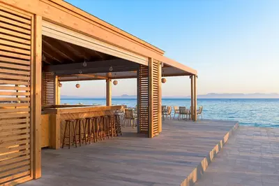 a wooden deck with a bar on the beach at Avra Beach Resort in Ixia