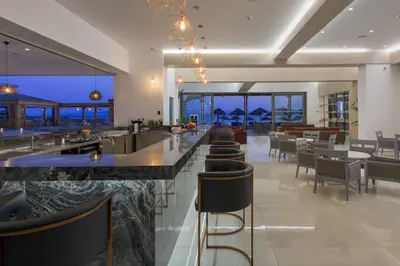 a bar in a restaurant with a view of the ocean at Avra Beach Resort in Ixia