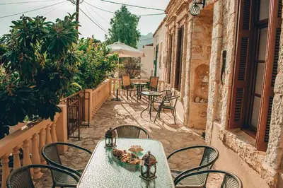 a table and chairs on a patio with tables and chairs at Kleanthe in Halki