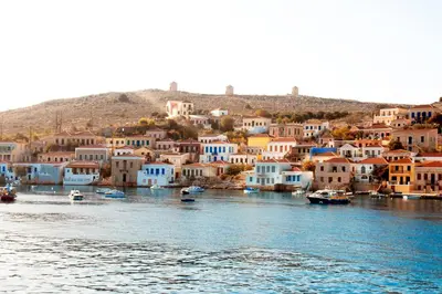 a view of a town with boats in the water at Kleanthe in Halki
