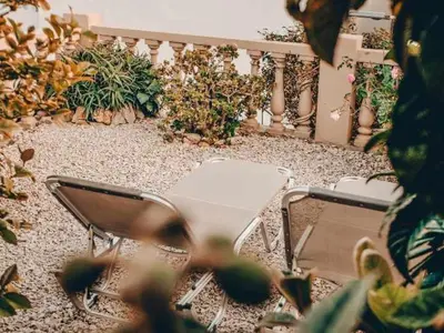 a patio with chairs and plants in a garden at Kleanthe in Halki