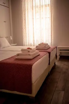 two beds with towels on top of them in a bedroom at Kleanthe in Halki